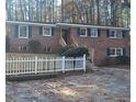 Charming brick home featuring a manicured lawn, white picket fence, and mature trees at 2289 Addison Rd, Marietta, GA 30066
