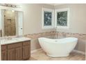 Bathroom featuring a freestanding tub, decorative windows, and tiled walk-in shower at 11575 Wildwood Springs Dr, Roswell, GA 30075