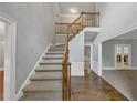 Bright foyer with hardwood floors, staircase, and view into a separate room at 11575 Wildwood Springs Dr, Roswell, GA 30075