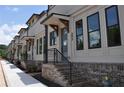 Modern townhome exterior with brick base, beige siding, black trim, and covered front entry at 293 White St # 2, Marietta, GA 30060