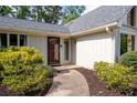 Close up of front door with mature landscaping including walkway lined with dark mulch and green shrubs at 297 Northgate Trce, Roswell, GA 30075