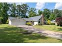 Ranch-style house with a stone chimney, a two-car garage and well-manicured lawn and mature landscaping at 297 Northgate Trce, Roswell, GA 30075