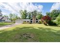 Ranch-style house with a stone chimney, a two-car garage and well-manicured lawn and mature landscaping at 297 Northgate Trce, Roswell, GA 30075