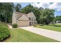 Well-maintained two-story home with a lush green lawn and a spacious driveway leading to a two-car garage at 516 Huntgate Rd, Woodstock, GA 30189