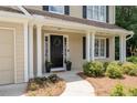 Inviting front porch with decorative wreath, landscaping, and elegant columns for added curb appeal at 516 Huntgate Rd, Woodstock, GA 30189