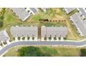 Aerial view of townhome with manicured lawns and neighborhood street at 191 Madison Bnd, Woodstock, GA 30188