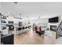 Open-concept living room with fireplace, kitchen, and modern finishes at 191 Madison Bnd, Woodstock, GA 30188