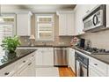 Modern kitchen with stainless steel appliances, white cabinetry, and granite countertops at 5029 Rosalie Rd, Johns Creek, GA 30022