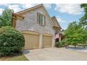 Spacious two-car garage with brick accents, and driveway at 895 Mill Garden Pl, Cumming, GA 30040