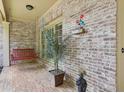 Covered porch featuring brick flooring, hanging swing, and decorative accents at 895 Mill Garden Pl, Cumming, GA 30040
