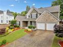 Attractive two-story home with brick, well-maintained landscaping, and an attached two-car garage at 977 Frog Leap Trail Nw, Kennesaw, GA 30152