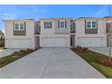 View of new townhomes with attached garages and modern exteriors under blue sky at 336 Heavenly Hollow Pl, Mcdonough, GA 30253