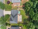 Aerial view of the backyard, showcasing a large patio, lush lawn, and mature trees at 530 Summerhill Dr, Roswell, GA 30075