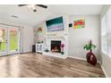 Cozy living room with a white fireplace, wood floors, and double doors to the outside at 1126 Mainstreet Valley Dr, Stone Mountain, GA 30088