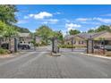 Gated community entrance with stone pillars, decorative lights, and well maintained brick streets at 1705 Brighton Pt, Atlanta, GA 30328
