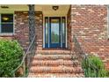 Close-up of a stylish blue front door framed by brick steps and wrought iron railings at 3292 Ferncliff Ne Pl, Atlanta, GA 30324