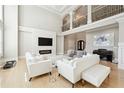 Bright, airy living room boasts soaring ceilings, a stone fireplace, and elegant white furnishings at 3423 Jamont Blvd, Alpharetta, GA 30022