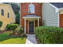 Inviting front entrance with a black door, brick facade, and lush green landscaping at 4284 Cabretta Se Dr, Smyrna, GA 30080