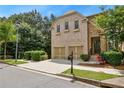 Beautiful home with a brick and stone exterior, a two-car garage, and lush green landscaping at 189 Privet Cir, Suwanee, GA 30024