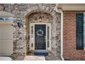 Elegant front entrance featuring a stone archway, a black door with a wreath, and sidelights at 255 Wembley Cir, Atlanta, GA 30328