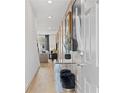 Hallway with light wood floors, mirrored table, and artwork leading into the living area at 332 Heavenly Hollow Pl, Mcdonough, GA 30253