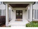 Covered front porch of white brick home featuring classic columns and a welcome mat at 3600 Morishop Nw Cv, Marietta, GA 30064