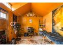 Vibrant orange shed interior featuring a desk, massage table, and unique decor, perfect for a studio or office at 3182 Latona Sw Dr, Atlanta, GA 30354
