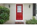 Close-up of the bright red front door framed by sconces and lush greenery at 4378 Heritage Glen Ct, Marietta, GA 30068