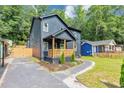 Charming two-story home featuring a covered porch, landscaped yard, and a modern, dark gray exterior at 445 Westmeath Sw Dr, Atlanta, GA 30310