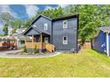 Charming two-story home featuring a covered porch, landscaped yard, and a modern, dark gray exterior at 445 Westmeath Sw Dr, Atlanta, GA 30310