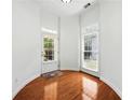 Bright foyer with hardwood floors, transom window over exterior door, and classic white trim at 12554 Huntington Trce, Alpharetta, GA 30005