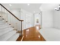 Bright foyer with staircase, hardwood floors, French doors and white trim throughout at 12554 Huntington Trce, Alpharetta, GA 30005