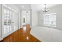 Formal living room features French doors, wainscoting, a large window, and hardwood flooring at 12554 Huntington Trce, Alpharetta, GA 30005