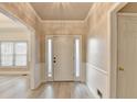 Inviting entryway with wainscoting, crown molding, and a view to the living area at 1610 Windsong Park Dr, Dacula, GA 30019
