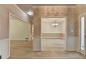 Open concept living area with crown molding and luxury vinyl flooring leading to dining room at 1610 Windsong Park Dr, Dacula, GA 30019