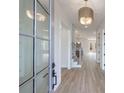 Bright hallway with light wood flooring, a staircase, and a view to other rooms of the home at 160 South Village Ave, Holly Springs, GA 30115