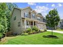 Lovely two-story home has a welcoming front porch, a well-kept yard, and a convenient three-car garage at 6045 Stargazer Way, Cumming, GA 30028