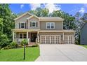 Inviting two-story home with a covered porch, manicured lawn, and a convenient three-car garage at 6045 Stargazer Way, Cumming, GA 30028