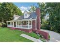 Charming brick house with a covered front porch, brick chimney, and landscaped surroundings at 6841 Fairway Ridge Dr, Douglasville, GA 30134