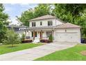 Attractive two-story home with a covered front porch, green lawn, and an attached two-car garage at 2602 Drew Valley Ne Rd, Brookhaven, GA 30319