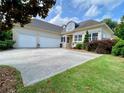 Charming home with a two-car garage and a wide driveway surrounded by lush greenery and a well-maintained lawn at 9602 Coastal Pointe Dr, Villa Rica, GA 30180