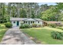 A lovely single-story home with a long, winding driveway, a green lawn, and mature trees behind the house at 1891 Sahara Se Dr, Atlanta, GA 30316