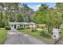 A lovely single-story home with a long driveway and a beautiful, green lawn, with mature trees behind the house at 1891 Sahara Se Dr, Atlanta, GA 30316