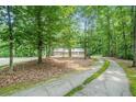 Scenic view of a long, mossy driveway leading to a brick home surrounded by lush trees at 1310 Chilton Woods Rd, Rutledge, GA 30663