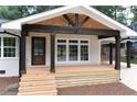 Inviting front porch with dark wood columns, exposed rafter tails, and light wood decking at 3590 Lee Se St, Smyrna, GA 30080