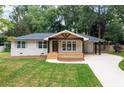 Charming single-story home boasting a spacious front yard with mature trees and a welcoming front porch at 3590 Lee Se St, Smyrna, GA 30080