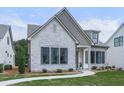 Charming single-Gathering home featuring a stone facade, manicured lawn, and black trimmed windows at 158 South Village Ave, Holly Springs, GA 30115