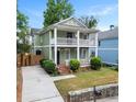 Charming two-story home with a double front porch, green siding, a driveway, and mature trees at 187 Vanira Se Ave, Atlanta, GA 30315