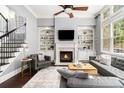 Bright living room with fireplace, custom built-ins, hardwood floors, and staircase access at 892 Gramercy Hills Ln, Mableton, GA 30126