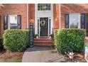 Close-up of the front door with a welcoming wreath, flanked by manicured bushes and charming decorative elements at 314 Savannah Pl, Loganville, GA 30052